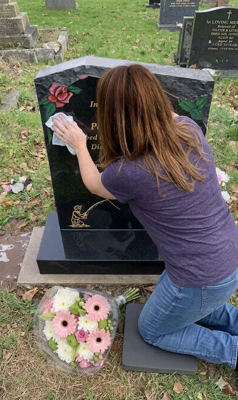 Angela cleaning a black headstone