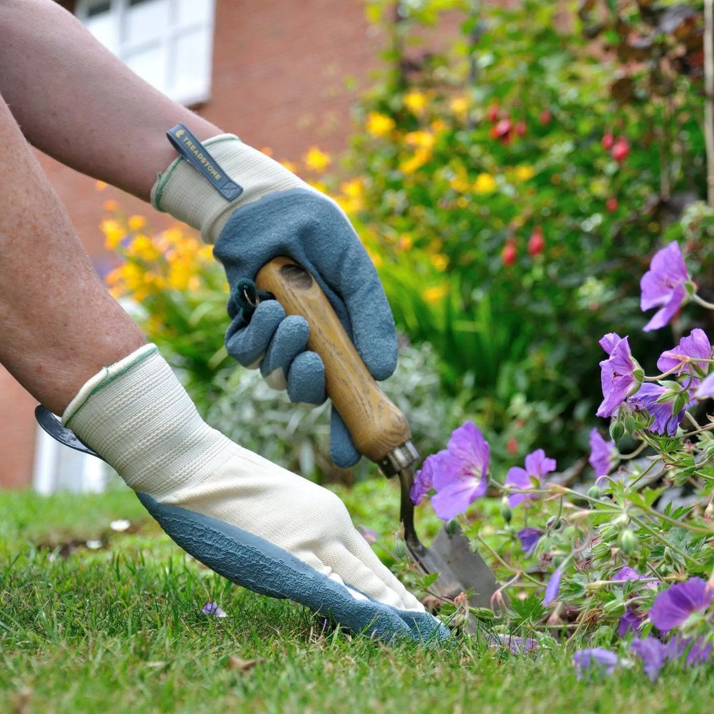 Weeding around a grave by hand